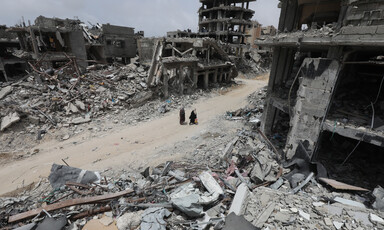 Two people walk through a scene of utter destruction in southern Gaza 