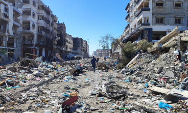 A man walks in the rubble of an area that has been attacked by Israeli forces 