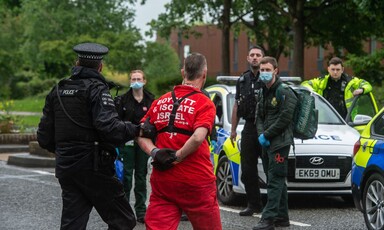 Police lead a man away in handcuffs