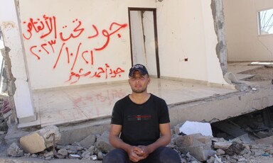 A man sits beside the remains of a home in central Gaza 