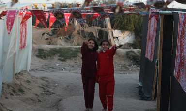 two girls walk between decorated tents