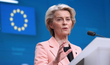 European Commission President Ursula von der Leyen stands at a podium against a blue background