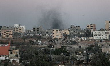 Smoke rises above buildings some of which are damaged or destroyed in Rafah 