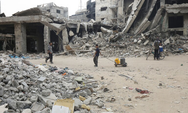 Children with water canisters among a scene of destruction in southern Gaza 
