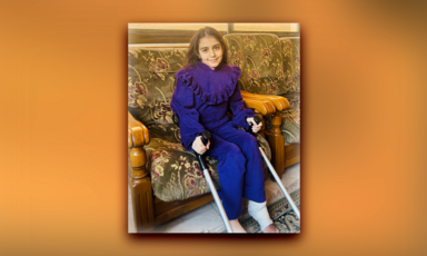 A portrait of a girl sitting down and holding crutches 