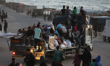 families on the back of a truck with their possessions