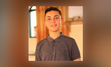 Portrait of a boy wearing a gray short sleeved shirt 