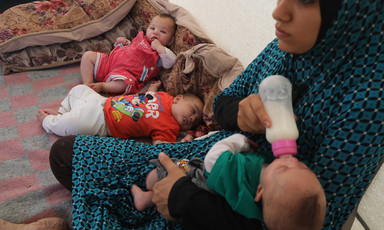 A mother feeds her baby milk