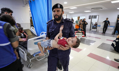 An emergency worker carries wounded child