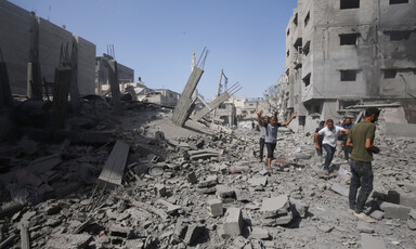 People walk in the rubble following an Israeli massacre in central Gaza 