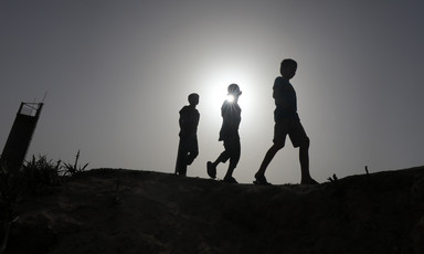 Three Palestinians walking as hundreds of thousands flee Rafah in southern Gaza