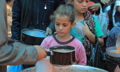 Children and some adults queue for food in Gaza 