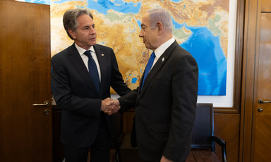 Secretary of State Antony Blinken shakes hands with Israeli Prime Minister Benjamin Netanyahu with a map behind them