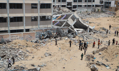 People gather beside a partially destroyed building in southern Gaza 