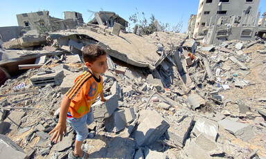 A boy moves through the remains of buildings in Gaza 