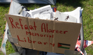 A cardboard sign reading Refaat Alareer Memorial Library 