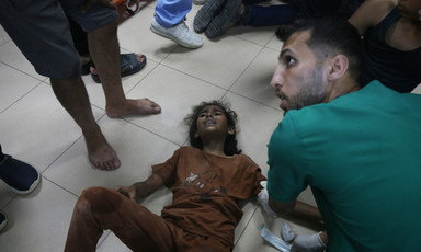 An injured child screams in pain on the floor of a hospital