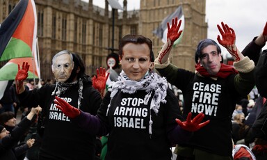 People wear masks showing the faces of politicians and T-shirts saying Stop Arming Israel and Ceasefire Now