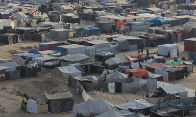 Dozens of tents fill a sandy space