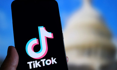 A TikTok logo is in front of a blurred image of the US Congress
