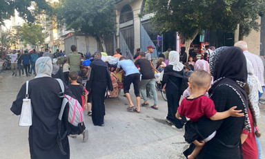 Parents holding children and others evacuate a Gaza City neighborhood