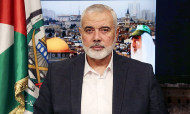 Ismail Haniyeh sits in front of backdrop showing Jerusalem holy sites