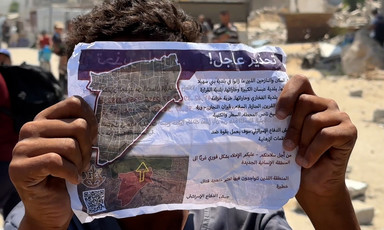 A person holds up an evacuation notice from Israel