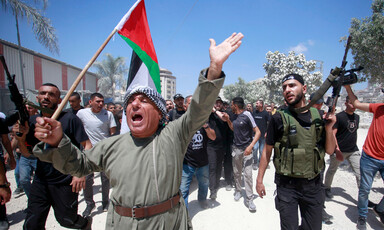 Palestinians carry weapons, flag during a funeral march 