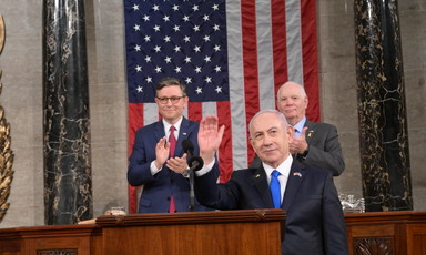 Benjamin Netanyahu stands in front of Mike Johnson, Ben Cardin and American flag