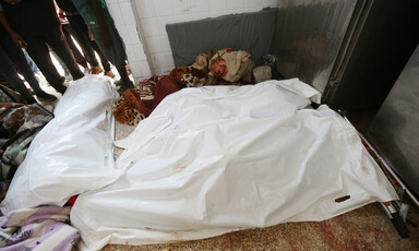 A number of dead bodies covered by shrouds 