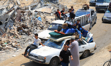 People sit on top of car with a mattress and other items on its room 