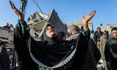 A woman raises her hands to the sky