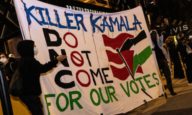 Two protesters stand alongside a banner that says Killer Kamala Do Not Come for our votes outside the DNC in Chicago, Illinois