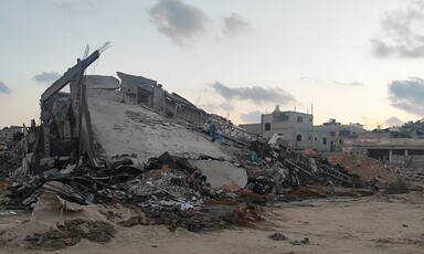 A collapsed house, its concrete roof sloping toward the ground