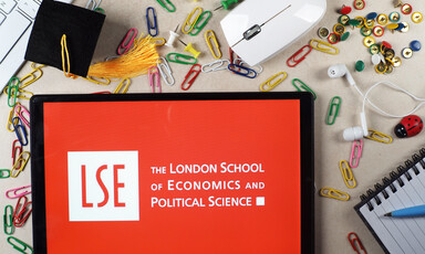 A tablet with the logo of the London School of Economics surrounded by a computer mouse and paper clips