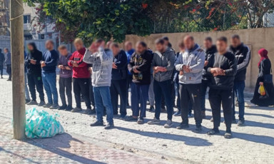 A group of people pray on a pavement