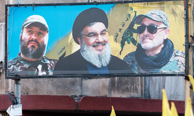 A billboard shows Nasrallah with two comrades 