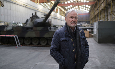 A man stands in front of a tank 