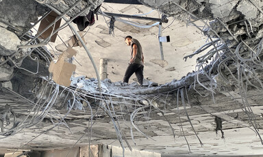 Photo taken from below shows man walking next to hole in floor of multi-story building
