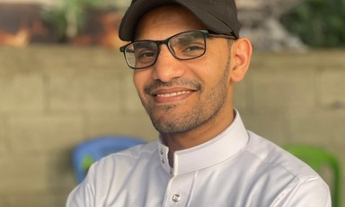 A young man smiles at the camera