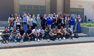 A group of students pose on the steps of a building