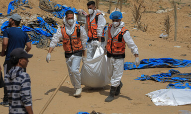 Three men in hazmat suits and face masks carry a wrapped body between them