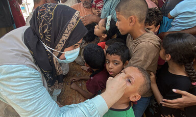 A woman administers a vaccine to a child