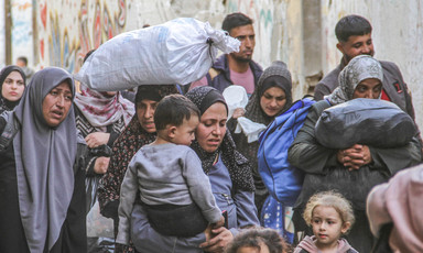 People carrying belongings, children and bags of rice are displaced from Jabaliya