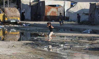 A girl walks through a puddle