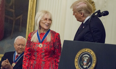 President Donald Trump at podium in East Room of White House with Miriam Adelson and Senator Orrin Hatch