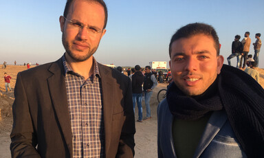 Refaat Alareer and Asem Alnabih look at the camera while standing with sun shining on their faces