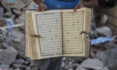 A man holds up a Quran