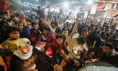 Crowd of men and boys put their arms up in the air