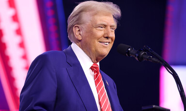 Donald Trump stands in front of microphones